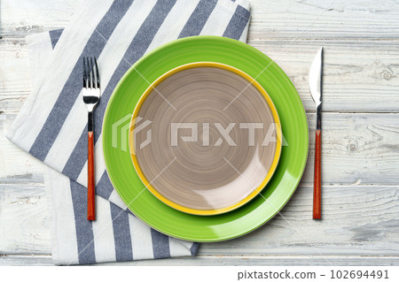 Top view of color ceramic plate on wooden background Top view of color ceramic plate on wooden background 102694491