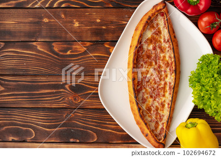 Pide - Turkish baked bread on wooden table Pide - Turkish baked bread on wooden table 102694672