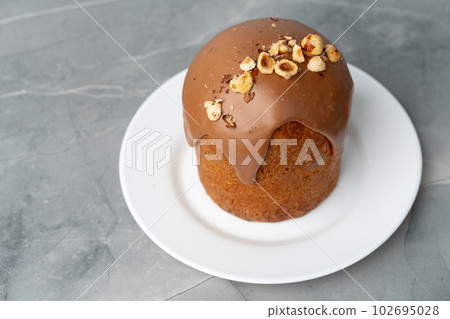 Ester cake with chocolate topping and nuts on gray background Ester cake with chocolate topping and nuts on gray background 102695028