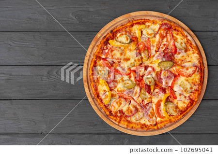 Top view of hot pizza on black wooden table Top view of hot pizza on black wooden table 102695041
