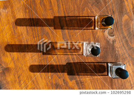 Set of perfume bottles on a bright light with shadows 102695298