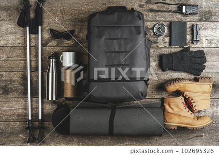 Backpack and hiking equipment on wooden background, top view Backpack and hiking equipment on wooden background, top view 102695326
