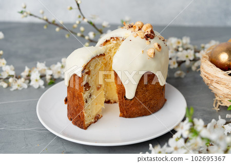 Piece of Easter cake on plate decorated with spring flower branches Piece of Easter cake on plate decorated with spring flower branches 102695367