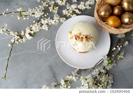 Easter cake and golden eggs on table Easter cake and golden eggs on table 102695408