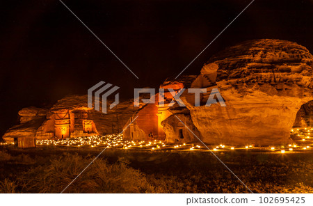 Ancient tombs of Hegra city illuminated during the night panorama, Al Ula, Saudi Arabia 102695425