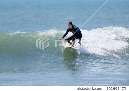 A man who enjoys surfing 102695475