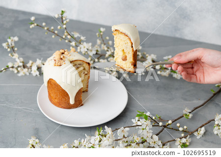 Hand holding piece of Easter cake on dessert spatula Hand holding piece of Easter cake on dessert spatula 102695519