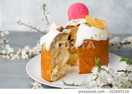 Piece of Easter cake on plate decorated with spring flower branches Piece of Easter cake on plate decorated with spring flower branches 102695538