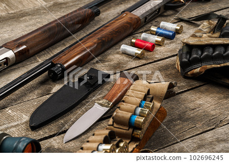 Various hunting equipment on old wooden background Various hunting equipment on old wooden background 102696245
