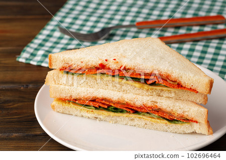 Double club sandwich served on plate on wooden table 102696464