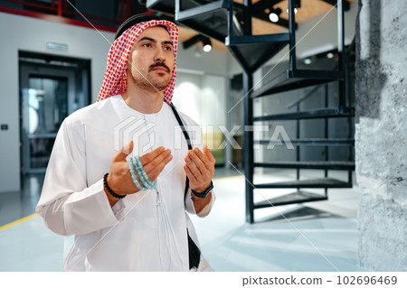 Young muslim man with rosary beads praying in the office Young muslim man with rosary beads praying in the office 102696469