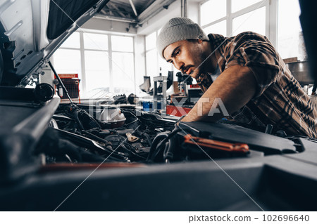 Mechanic examining car in auto car repair service center Mechanic examining car in auto car repair service center 102696640