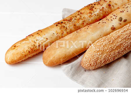 Fresh baguette bread on white wooden table Fresh baguette bread on white wooden table 102696934