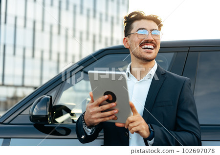 Young businessman using digital tablet while standing outdoors Young businessman using digital tablet while standing outdoors 102697078