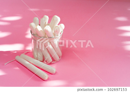 Feminine hygienic tampons on pink paper background Feminine hygienic tampons on pink paper background 102697153
