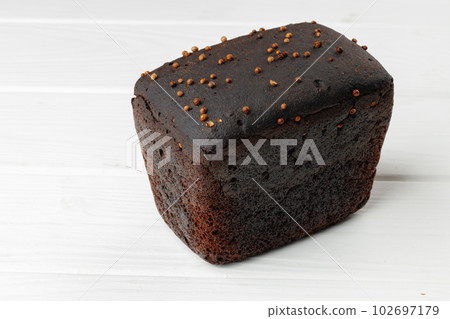 Loaf of rye bread on white wooden table 102697179