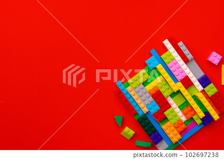 Plastic constructor details on red background close up Plastic constructor details on red background close up 102697238