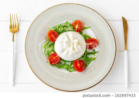 Salad with burrata cheese and cherry tomatoes on white wooden background 102697433