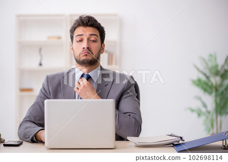 Young male employee and too much work in the office 102698114