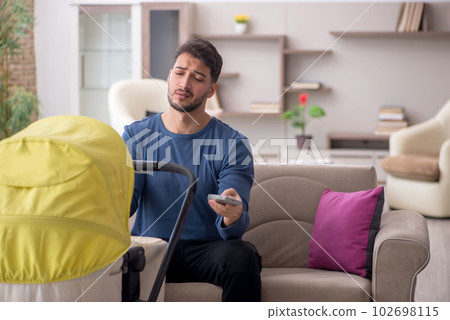 Young man looking after newborn at home 102698115