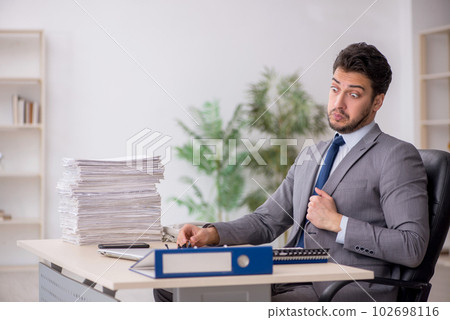 Young male employee and too much work in the office 102698116