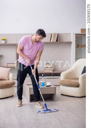 Young male contractor cleaning the house 102698170