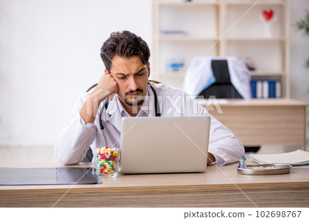 Young male doctor working in the clinic 102698767