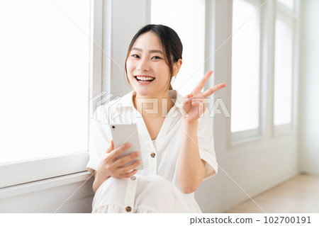 A woman watching a smartphone A woman watching a smartphone 102700191