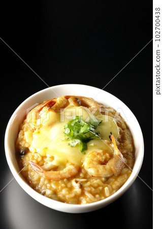 Shrimp, cheese, coriander and tom yum risotto shot against a black background Shrimp, cheese, coriander and tom yum risotto shot against a black background 102700438