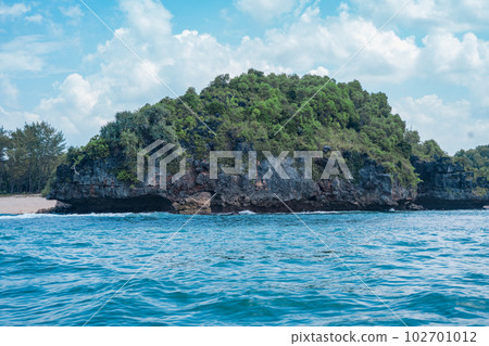 Rock formation on the ocean near the Tanjung Kasap or Cape Kasap, Pacitan, Indonesia. Taken from a moving boat. Rock formation on the ocean near the Tanjung Kasap or Cape Kasap, Pacitan, Indonesia. Taken from a moving boat. 102701012