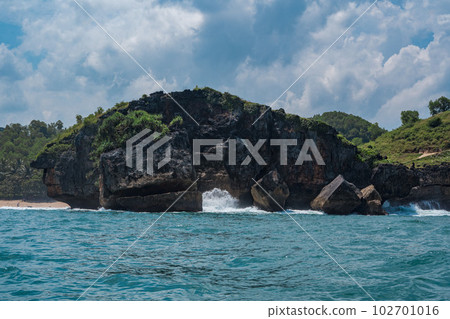 Rock formation on the ocean near the Tanjung Kasap or Cape Kasap, Pacitan, Indonesia. Taken from a moving boat. Rock formation on the ocean near the Tanjung Kasap or Cape Kasap, Pacitan, Indonesia. Taken from a moving boat. 102701016