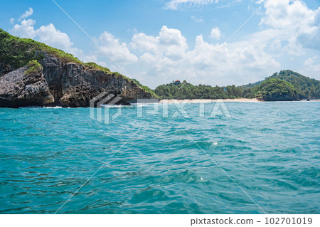 Rock formation on the ocean near the Tanjung Kasap or Cape Kasap, Pacitan, Indonesia. Taken from a moving boat. Rock formation on the ocean near the Tanjung Kasap or Cape Kasap, Pacitan, Indonesia. Taken from a moving boat. 102701019