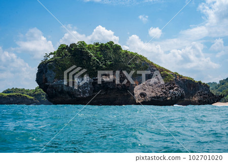 Rock formation on the ocean near the Tanjung Kasap or Cape Kasap, Pacitan, Indonesia. Taken from a moving boat. Rock formation on the ocean near the Tanjung Kasap or Cape Kasap, Pacitan, Indonesia. Taken from a moving boat. 102701020