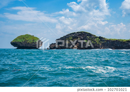 Rock formation on the ocean near the Tanjung Kasap or Cape Kasap, Pacitan, Indonesia. Taken from a moving boat. Rock formation on the ocean near the Tanjung Kasap or Cape Kasap, Pacitan, Indonesia. Taken from a moving boat. 102701021