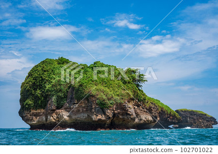 Rock formation on the ocean near the Tanjung Kasap or Cape Kasap, Pacitan, Indonesia. Taken from a moving boat. Rock formation on the ocean near the Tanjung Kasap or Cape Kasap, Pacitan, Indonesia. Taken from a moving boat. 102701022