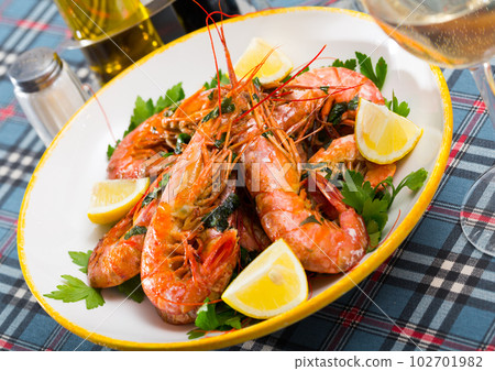 Appetizing fried shrimps with lemon and parsley 102701982