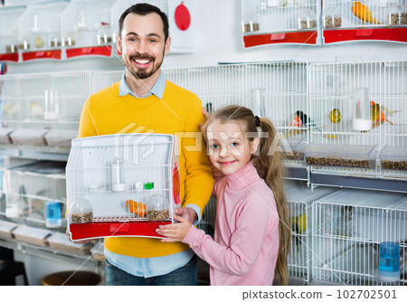 Father and daughter boasting their purchase of canary bird 102702501