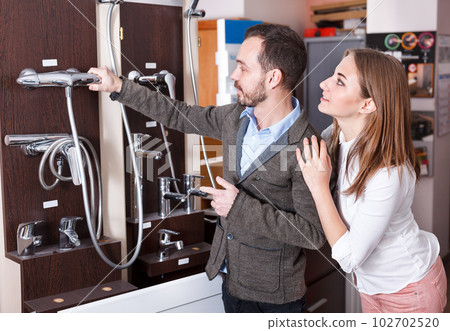 Couple choosing new shower mixer in store Couple choosing new shower mixer in store 102702520