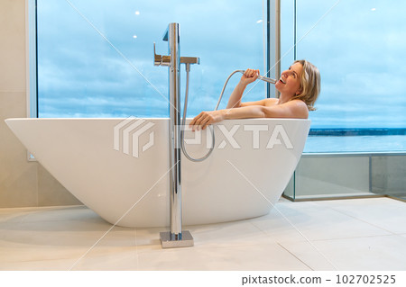 woman in freestanding white bath. Modern bathroom interior design. Beauty, healthy lifestyle concept 102702525