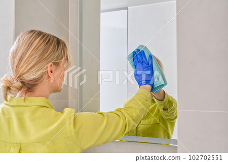 cleaning company. hotel maid microfiber cloth washing cleaning a mirror. household service concept 102702551