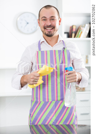 Young man in apron cleaning table 102702862