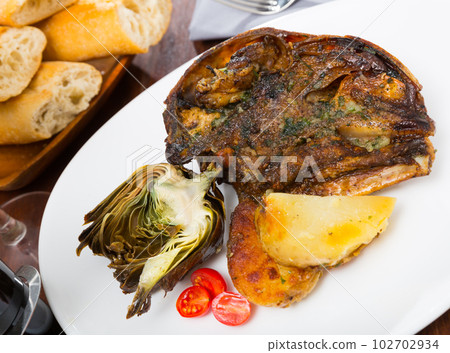 Cabeza de cordero - spanish dish. Lamb head with artichoke, tomatoes and potatoes 102702934