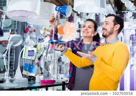 Smiling man and girl in lighter shop choose desk lamp Smiling man and girl in lighter shop choose desk lamp 102703038