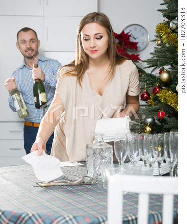 Couple serving table for Christmas dinner 102703313