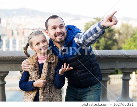 Father and daughter walking in city 102703381