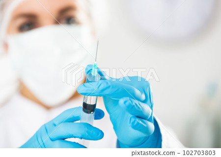 Young female nurse ready to make injection 102703803
