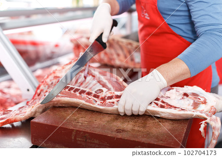 Close-up of butcher cutting quality porks Close-up of butcher cutting quality porks 102704173