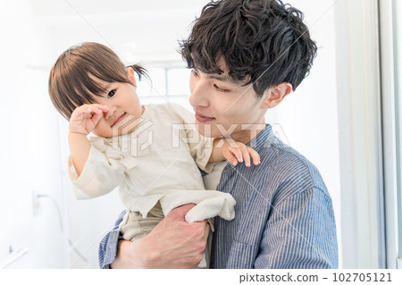 一名嬰兒在洗手間被父親抱住,因困倦而揉一隻眼睛 一名嬰兒在洗手間被父親抱住,因困倦而揉一隻眼睛 102705121