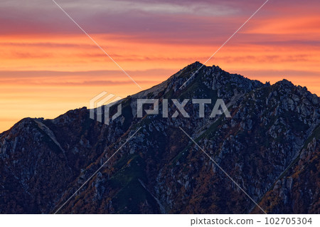 Sunrise clouds and Mt. Utsugi seen from Mt. Kumazawa, the main ridgeline of the Central Alps 102705304