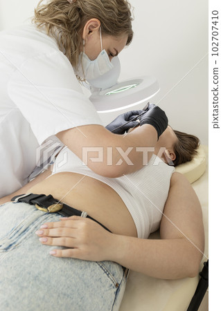 Dermatologist Removing Hair On Chin Of Patient's Face With Electrolysis Procedure, Electric Epilation In Beauty Salon. Hair Removal Treatment. Vertical Plane 102707410